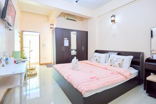 a bedroom with a large bed with pink sheets at SCN City Hotel Rayong in Ban Chang