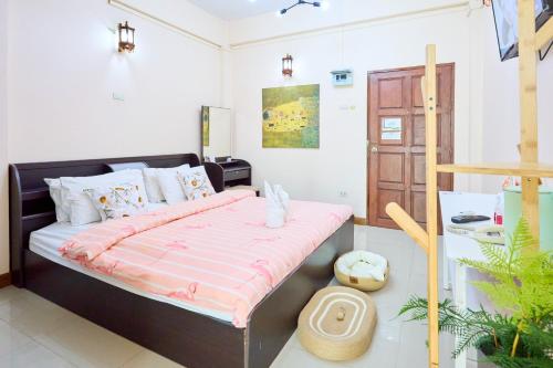 a bedroom with a large bed with a pink comforter at SCN City Hotel Rayong in Ban Chang
