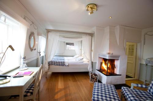 a bedroom with a bed and a fireplace in it at Tällbergsgårdens Hotell in Tällberg