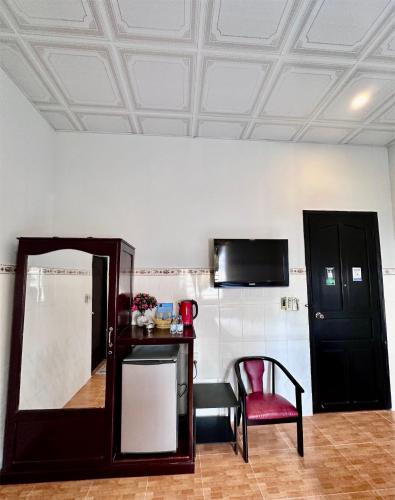a room with a mirror and a chair and a tv at Nam Đô Hotel Cần Thơ Downtown in Can Tho