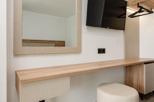 a room with a mirror and a tv on a wall at Caretta Beach Resort & WaterPark in Kalamaki