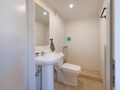 a white bathroom with a toilet and a sink at Spa Guest House by White Hills in the Heart of Arachova in Arachova