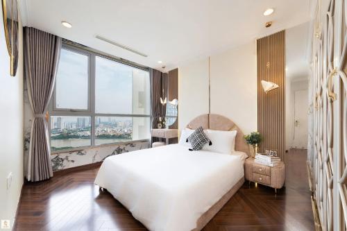 a bedroom with a large white bed and a large window at The Peak Suite at Landmark Plus in Ho Chi Minh City