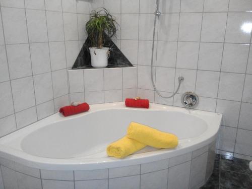 ハイリゲンブルートにあるHaus Benediktのバスタブ(黄色と赤のタオル付)