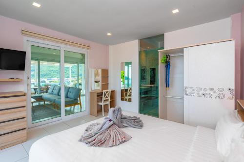 a bedroom with a bed and a television and a chair at Kata Hill Sea View Hotel in Kata Beach