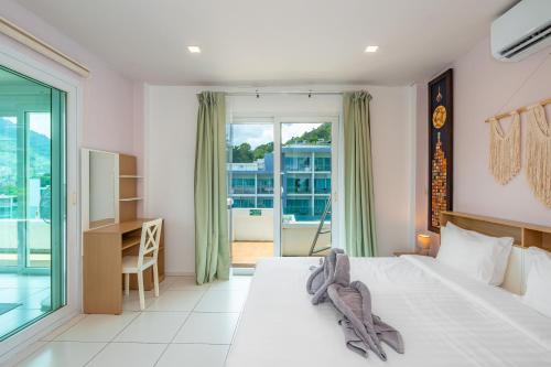 a bedroom with a large bed and a balcony at Kata Hill Sea View Hotel in Kata Beach
