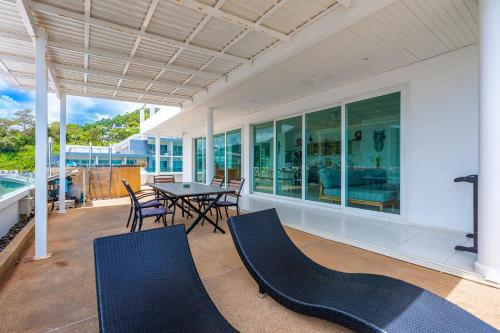 a patio with a table and chairs on a house at Kata Hill Sea View Hotel in Kata Beach