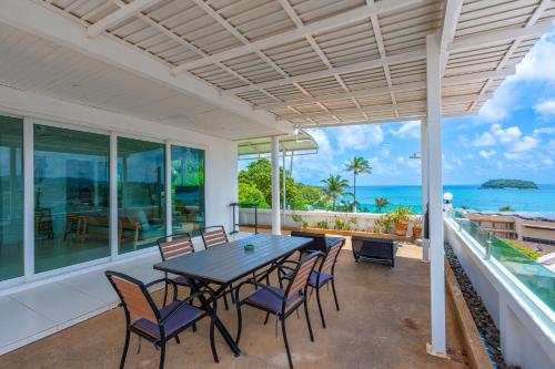 a dining room with a table and chairs and the ocean at Kata Hill Sea View Hotel in Kata Beach