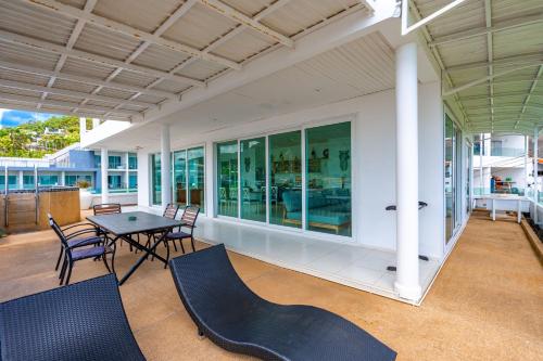 a patio with a table and chairs on a house at Kata Hill Sea View Hotel in Kata Beach