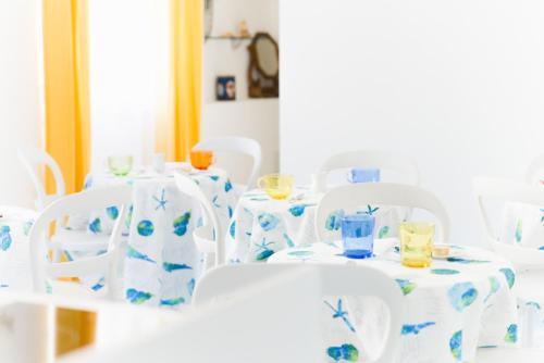 a group of white chairs and tables with glasses on them at La Casa di Aurora in Maiori