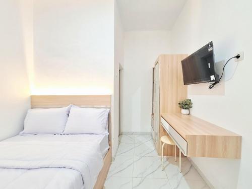 a small bedroom with a bed and a desk at Dahayu House Kaliurang Yogyakarta RedPartner in Ngemplak
