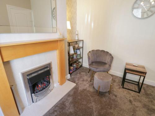 a living room with a fireplace and a chair at Coastal Corner in Whitby