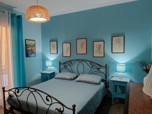 a bedroom with blue walls and a bed with two tables at Casa Azzurra in Giardini Naxos
