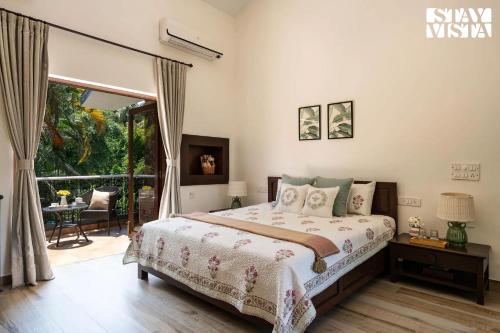 a bedroom with a bed and a large window at StayVista at Waves by the Beach with Beach Access, Pool, Lawn in Alibag