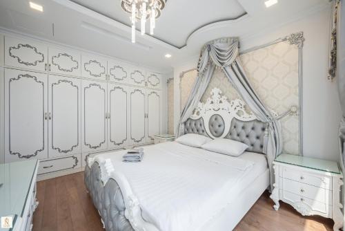 a bedroom with a white bed with a canopy at The Peak Suite at Landmark Plus in Ho Chi Minh City