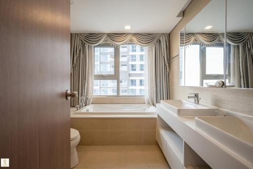 a bathroom with two sinks and a tub and a toilet at The Peak Suite at Landmark Plus in Ho Chi Minh City