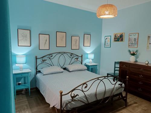 a bedroom with blue walls and a bed with two tables at Casa Azzurra in Giardini Naxos