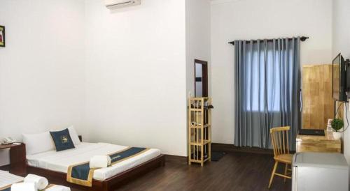 a bedroom with a bed and a desk and a chair at HON BA LAGI BEACH RESORT in La Gi