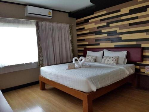 a bedroom with a bed with two white bows on it at Cactus Resort & Hotel in Khon Kaen