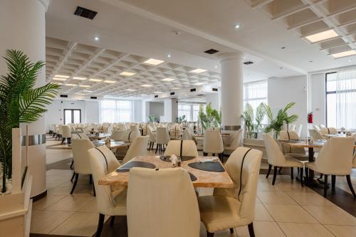 a dining room with tables and chairs at Caretta Beach Resort & WaterPark in Kalamaki