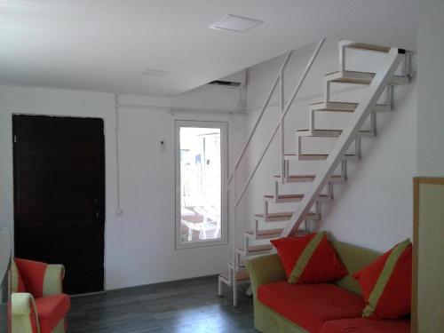 a living room with a staircase and a red couch at BEATRIS in Ureki