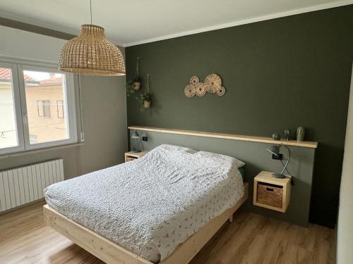 a bedroom with a bed and a green wall at Vivere Nient'Altro between port and historic center in Marano Lagunare