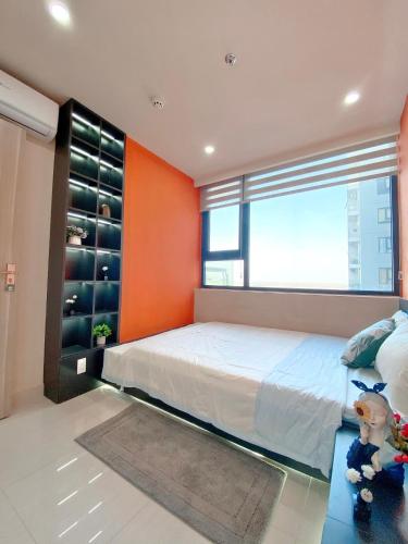 a bedroom with a bed with an orange wall at Thương Apartment 1 in Thôn Văn Dương