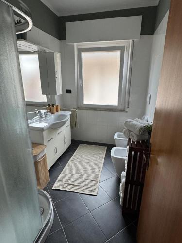 a bathroom with two sinks and a toilet and a window at Vivere Nient'Altro between port and historic center in Marano Lagunare