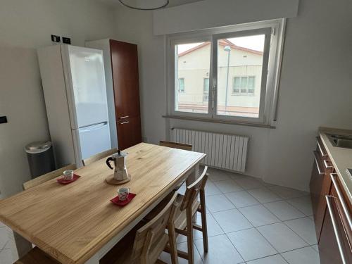 a kitchen with a wooden table and a refrigerator at Vivere Nient'Altro between port and historic center in Marano Lagunare