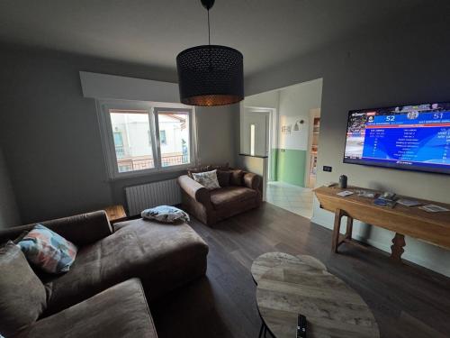 a living room with a couch and a flat screen tv at Vivere Nient'Altro between port and historic center in Marano Lagunare