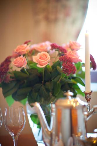 a vase with a bouquet of flowers and two candles at Tällbergsgårdens Hotell in Tällberg