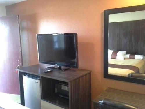 a flat screen tv sitting on a stand in a room at Budget Inn Tonawanda in Tonawanda