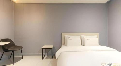 a bedroom with a bed and a table and a chair at Chuncheon World Hotel in Chuncheon