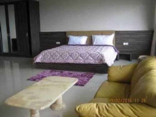 a bedroom with a bed and a couch at Fafa Hill Hotel and Resort in Bogor