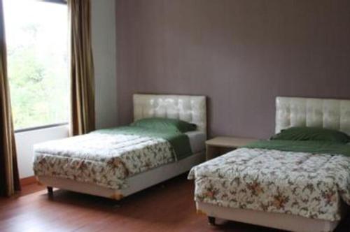 a bedroom with two beds and a window at Fafa Hill Hotel and Resort in Bogor