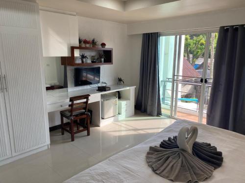 a bedroom with a bed with a chair and a table at Bestin Kata in Ban Karon