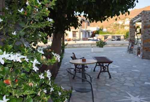 a table and chairs next to a tree with flowers at Anastasia Apartments in Korissia