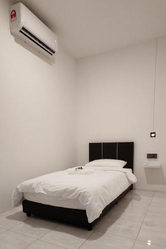 a white bedroom with a bed and a air conditioner at 23 Inn Singlebed Share Bathroom No Window in Bukit Mertajam