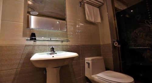 a bathroom with a sink and a toilet and a mirror at Jeju Sejong Hotel in Jeju