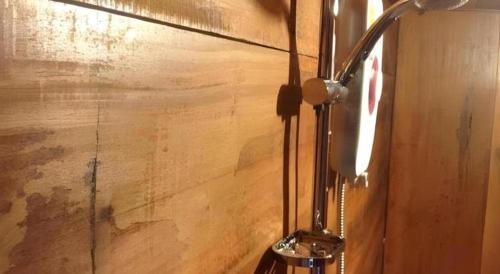 eine Nahaufnahme einer Lampe an einer Holzwand in der Unterkunft Jidapa Resort in Ban Khlong Takhian