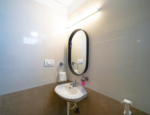 a bathroom with a sink and a mirror at Olive Zip Domlur by Embassy Group in Bengaluru