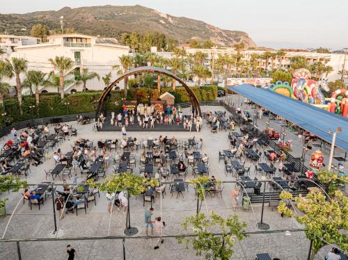 a group of people sitting at tables in a park at Caretta Beach Resort & WaterPark in Kalamaki
