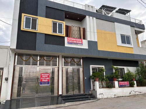 a building with closed doors and signs on it at Shivaksh Rental Flats and Rooms- Best Hotel in Bhawani Mandi in Bhawāni Mandi
