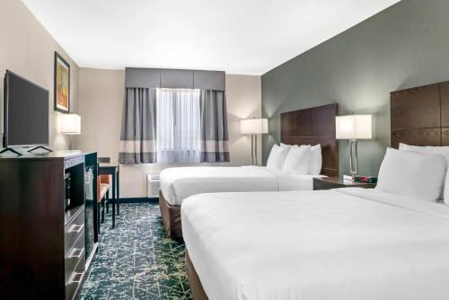 a hotel room with two beds and a television at Quality Inn Grand Rapids South-Byron Center in Grand Rapids