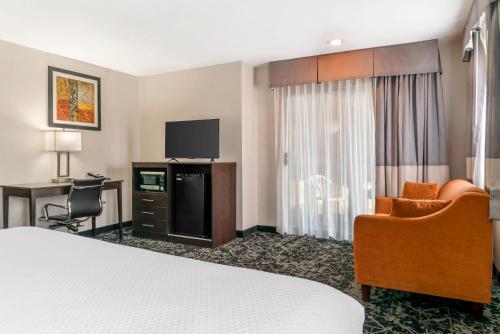 a hotel room with a bed and a desk and a tv at Quality Inn Grand Rapids South-Byron Center in Grand Rapids