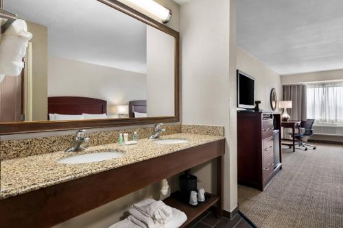 a hotel bathroom with two sinks and a large mirror at Comfort Inn & Suites North East in North East
