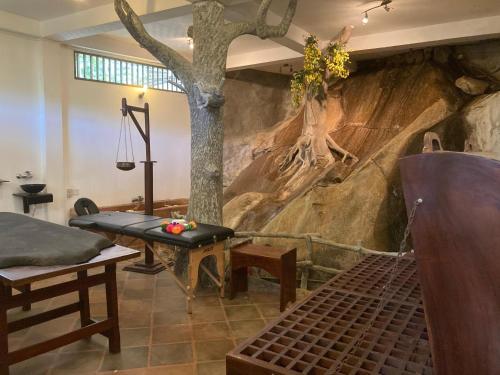 a room with a tree mural on the wall at Ayurweda spa Hotel in Deniyaya