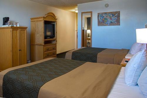 a hotel room with two beds and a television at Econo Lodge Rawlins in Rawlins
