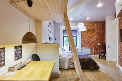 a room with a wooden table and a room with a bed at Kaleidoscope on Italyanskaya in Saint Petersburg