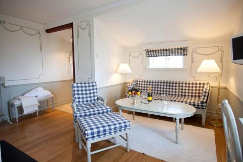 a living room with a couch and a table and chairs at Tällbergsgårdens Hotell in Tällberg